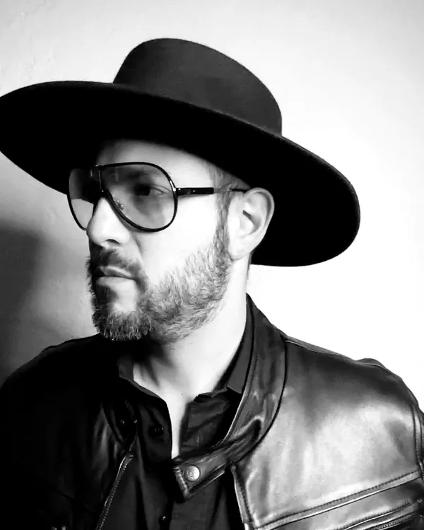Retrato en blanco y negro de Chema Dávila Bucio con sombrero y chamarra de piel